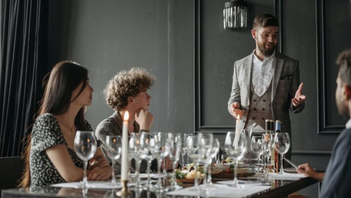 Friends enjoy an elegant wine tasting guided by a sommelier in a stylish indoor setting.